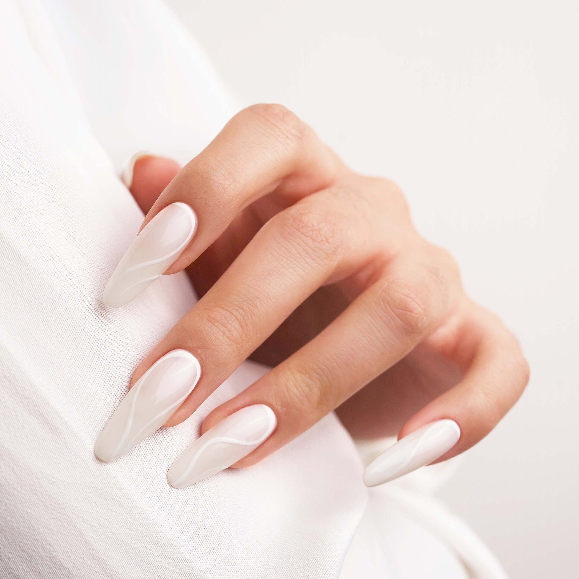 Design bianco su Gel Tips Mandorla: eleganza e delicatezza per ogni occasione.