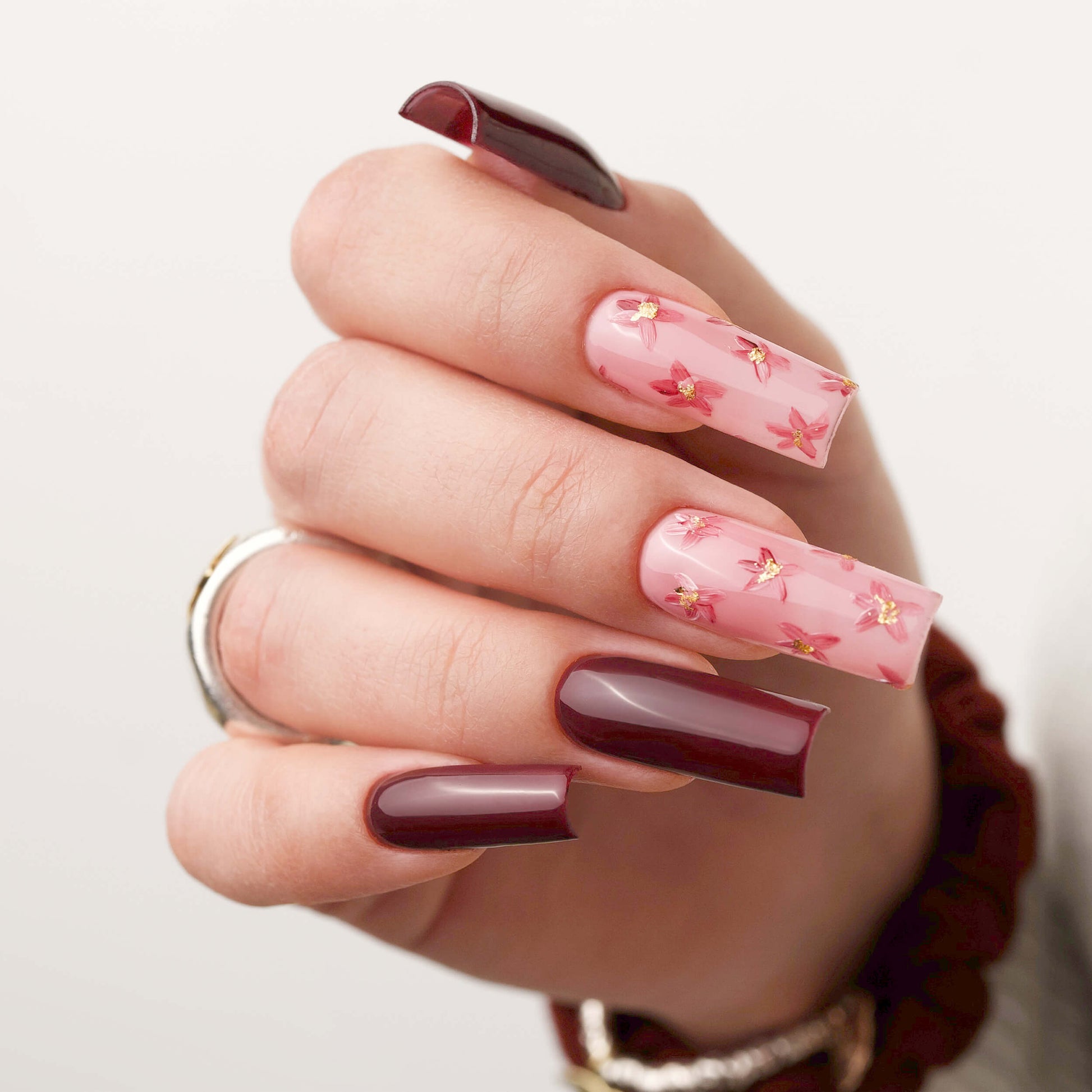 Manicure con Gel Tips Quadrato: un mix di eleganza floreale e audacia con colori intensi.