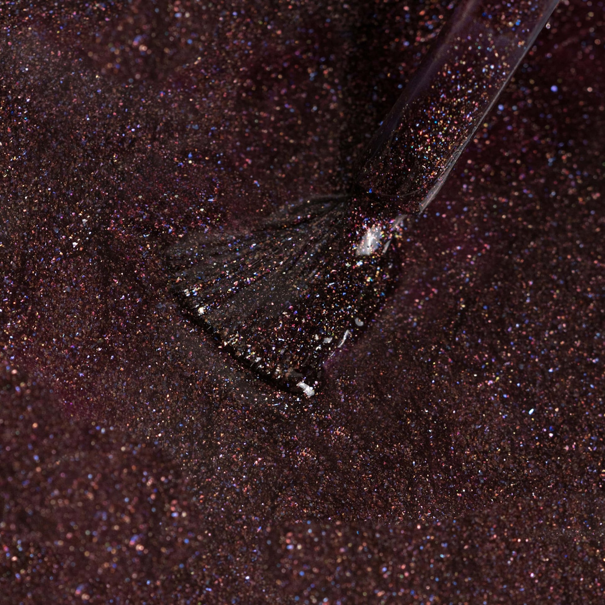 Glitter rosso scuro applicato su pennello in primo piano