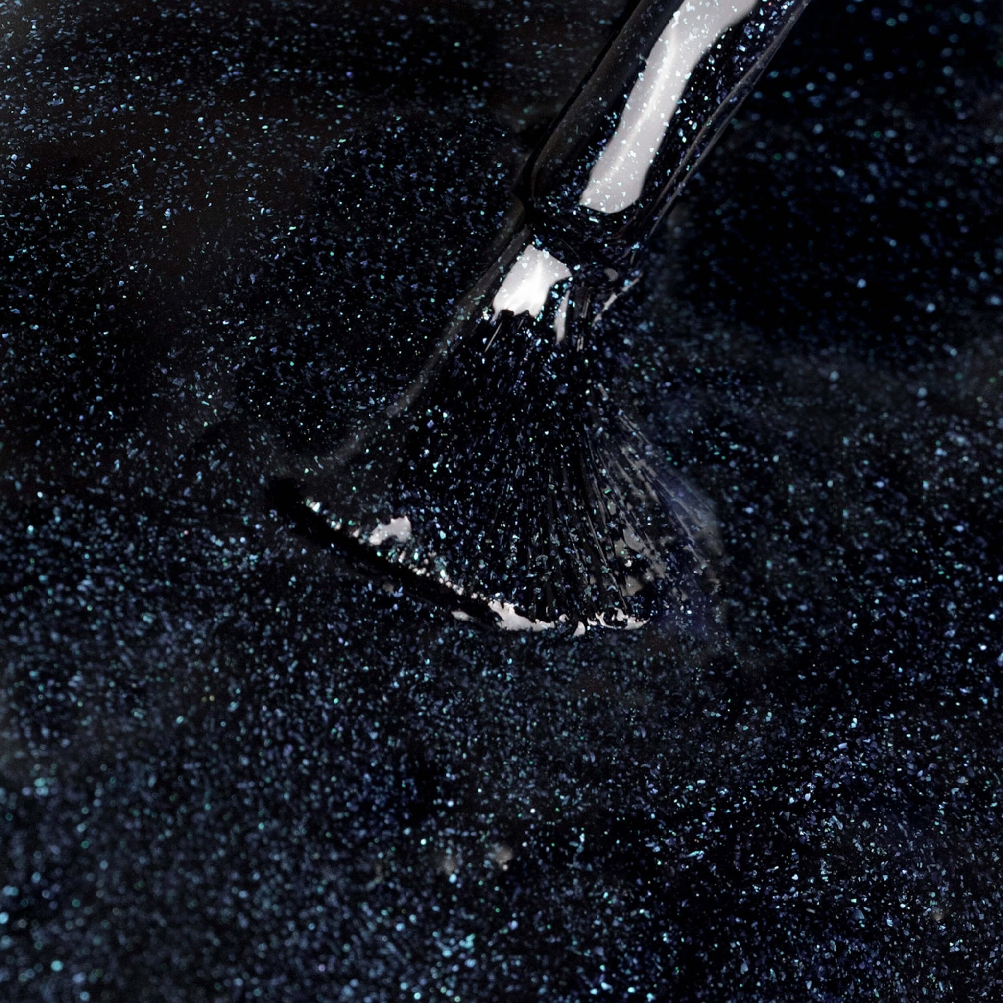 Close-up di smalto glitterato nero intenso applicato su pennello